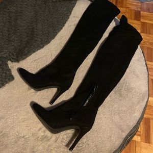High heeled black knee high boots